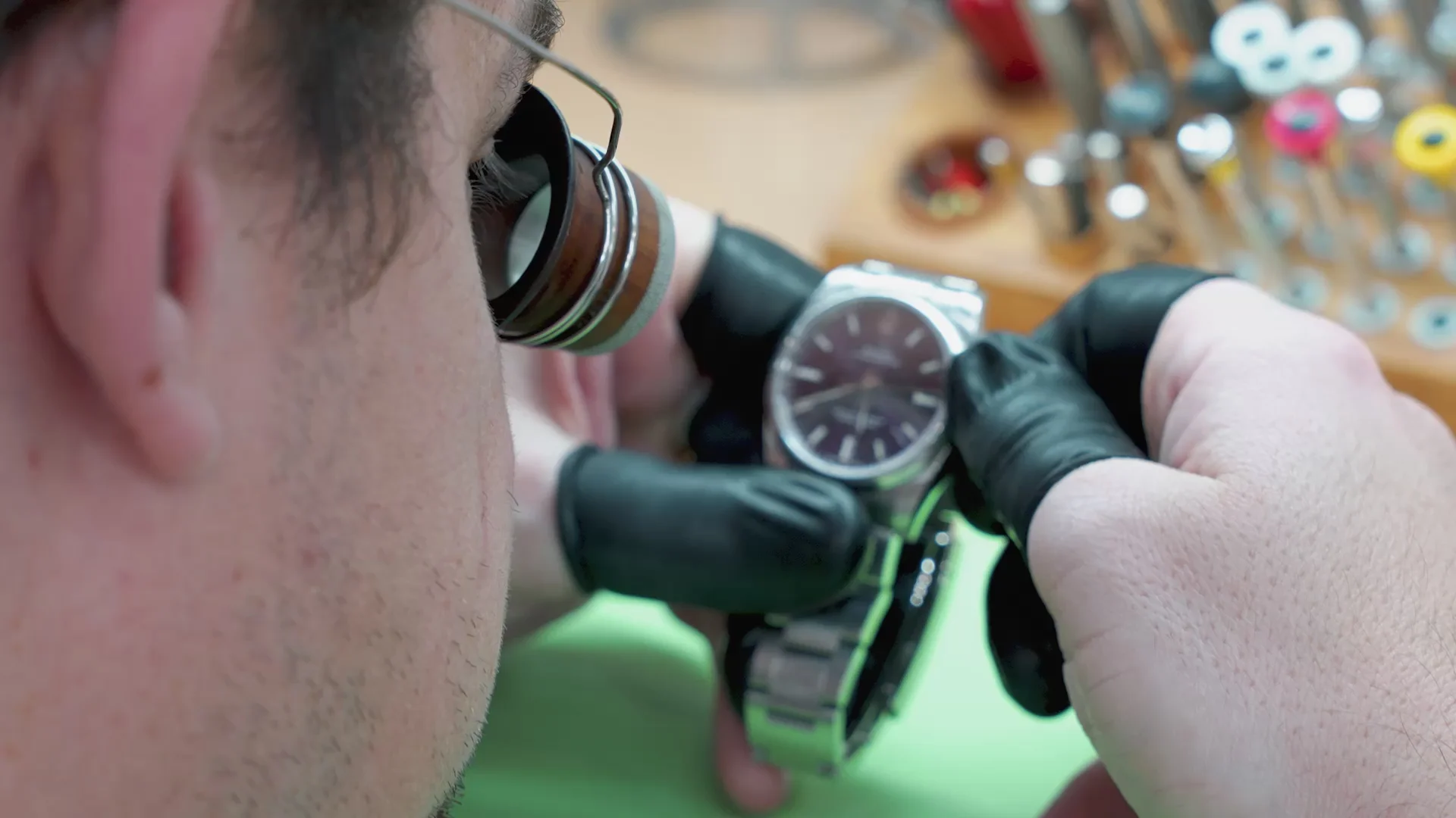 Watch repair specialist examining a wristwatch case and delicate external components