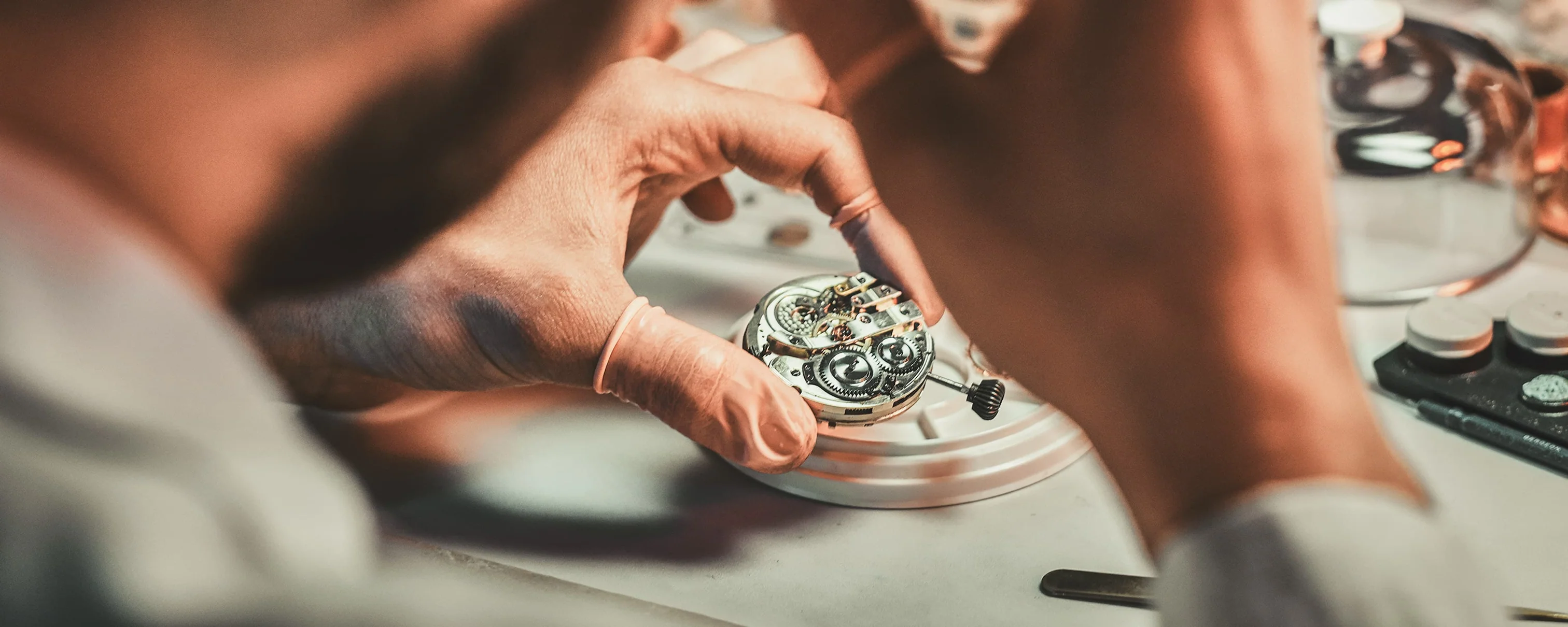 Watchmaker inspecting a mechanical movement with precision repair tools